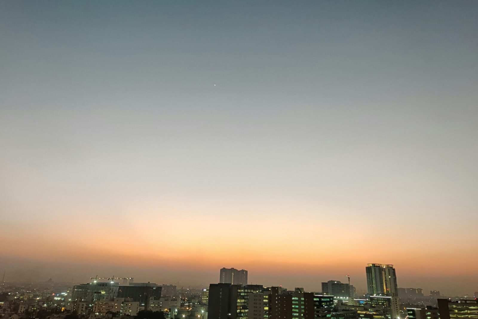 View across a sprawling city at dusk seen from a high-rise building