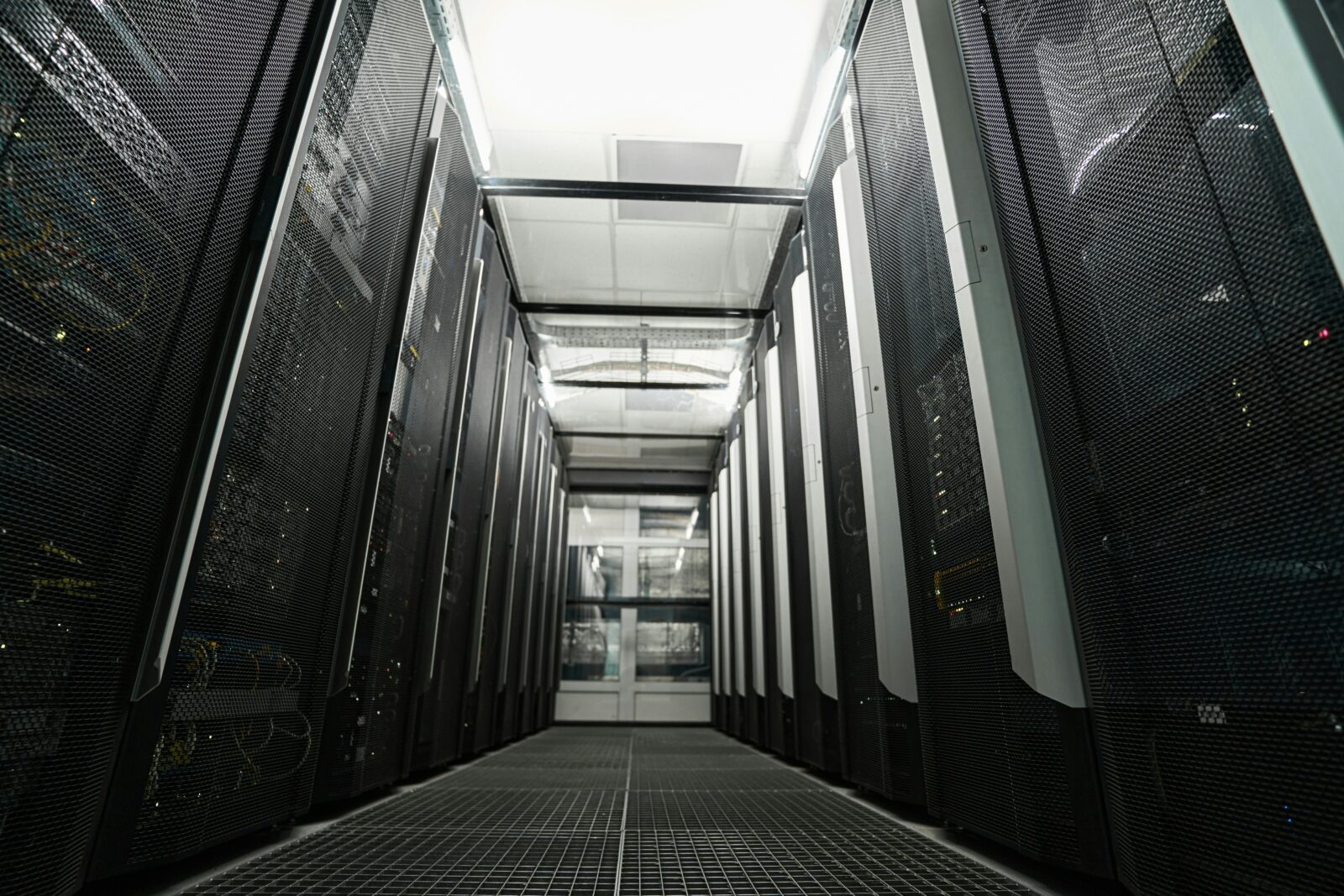 Empty aisle between rows of black server cabinets in a data centre