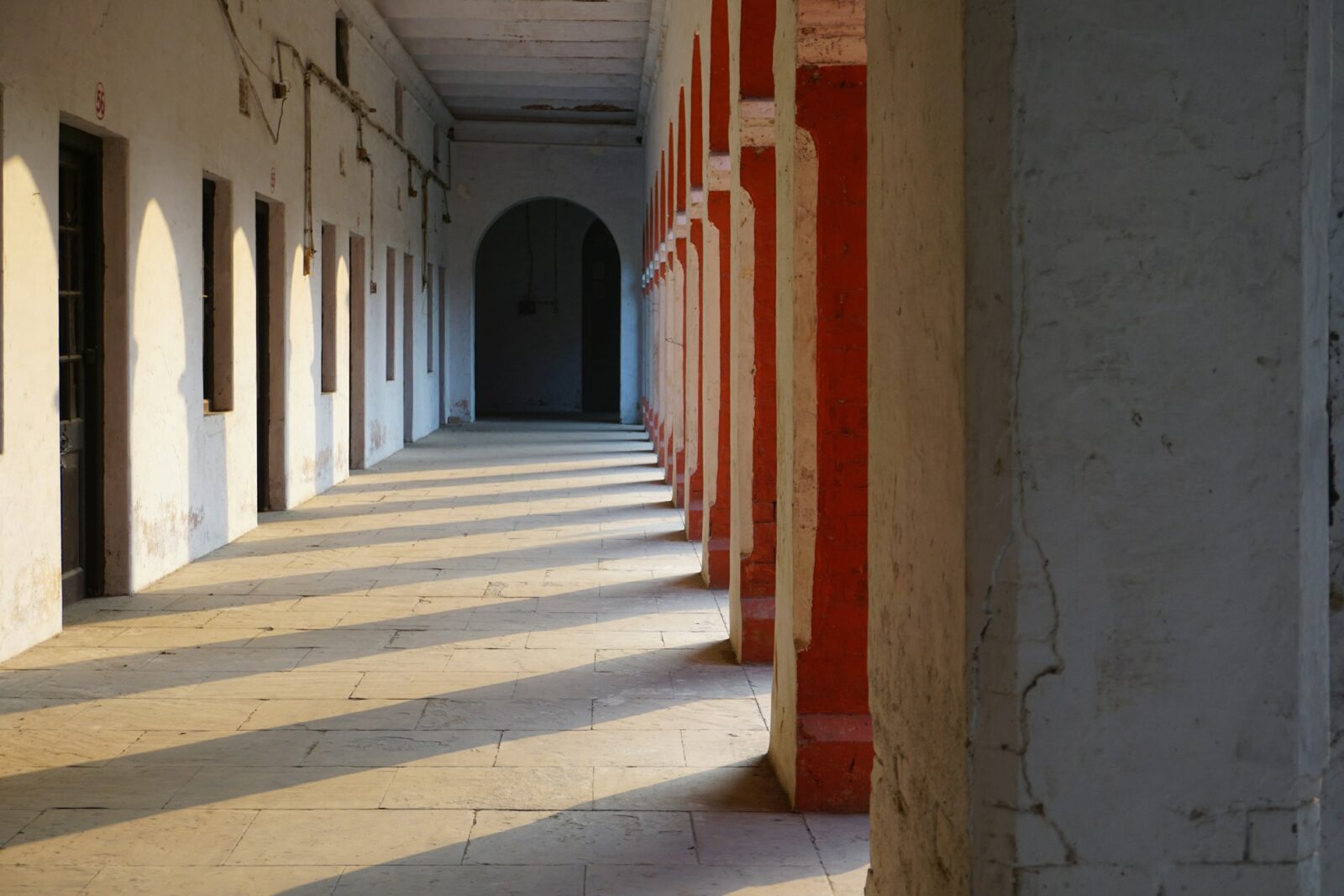 IIM Calcutta Teachers Concerned Over Institute Allowing Students to Stay on Campus A long, empty hallway lined with red and white columns