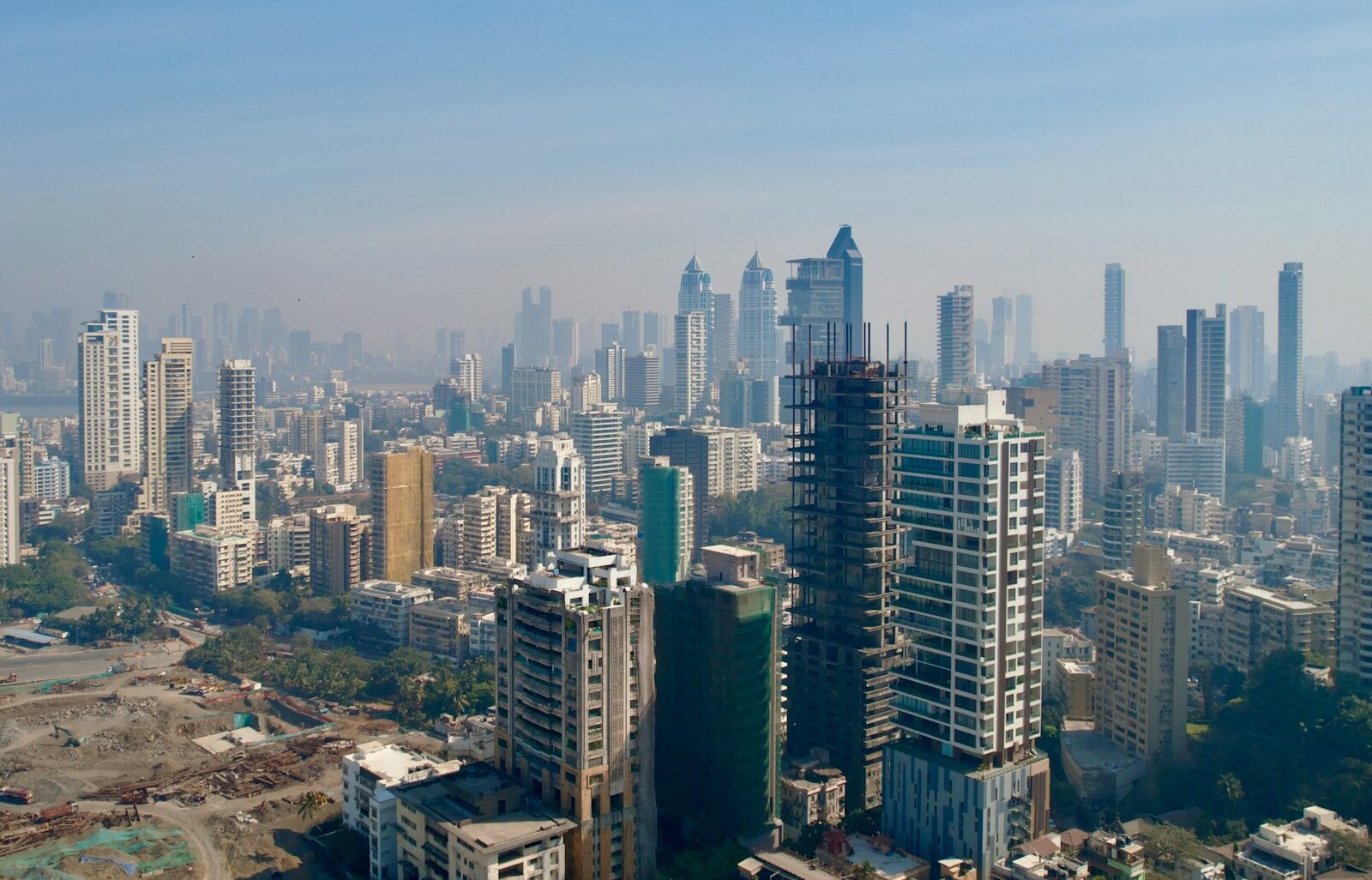 Tall residential towers on the Mumbai skyline seen through a light haze
