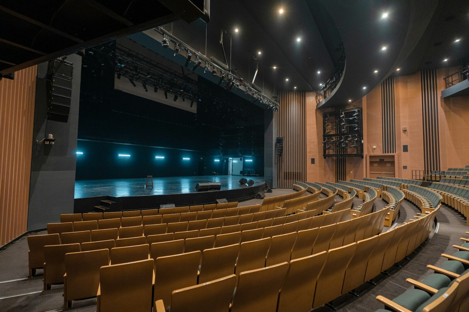 The Impact of NEP 2020 on Higher Education Empty auditorium with curved rows of wooden seats facing a dimly lit stage