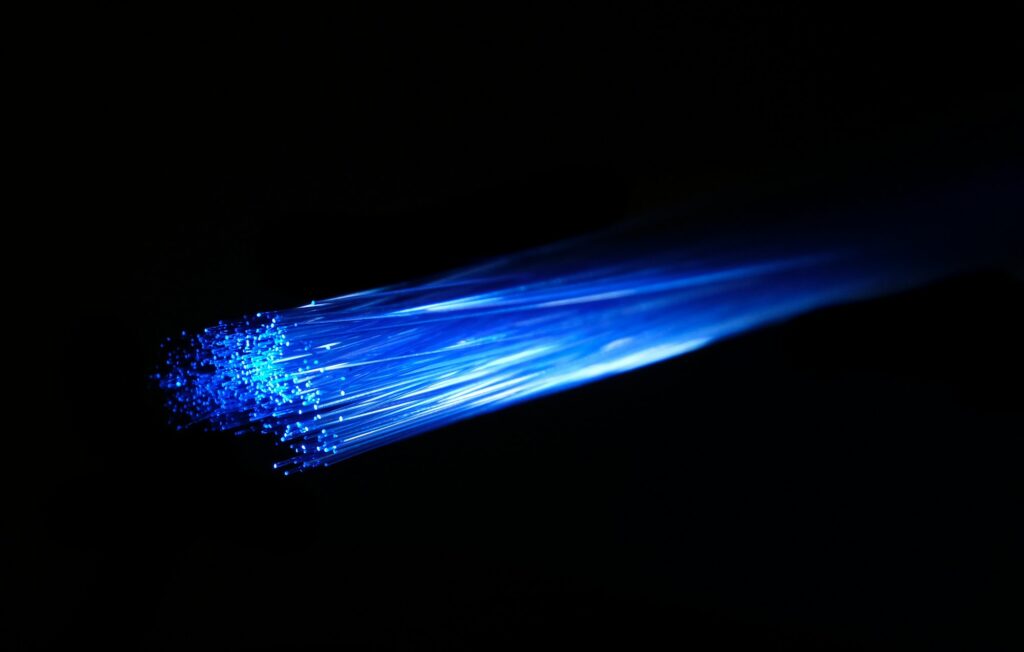 AICTE to collaborate with Microsoft for up-skilling educators and students Blue light travelling along a bundle of optical fibres against a black background