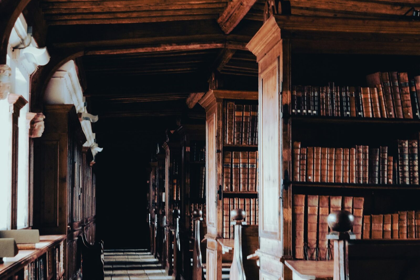 A long row of wooden bookshelves lining a library