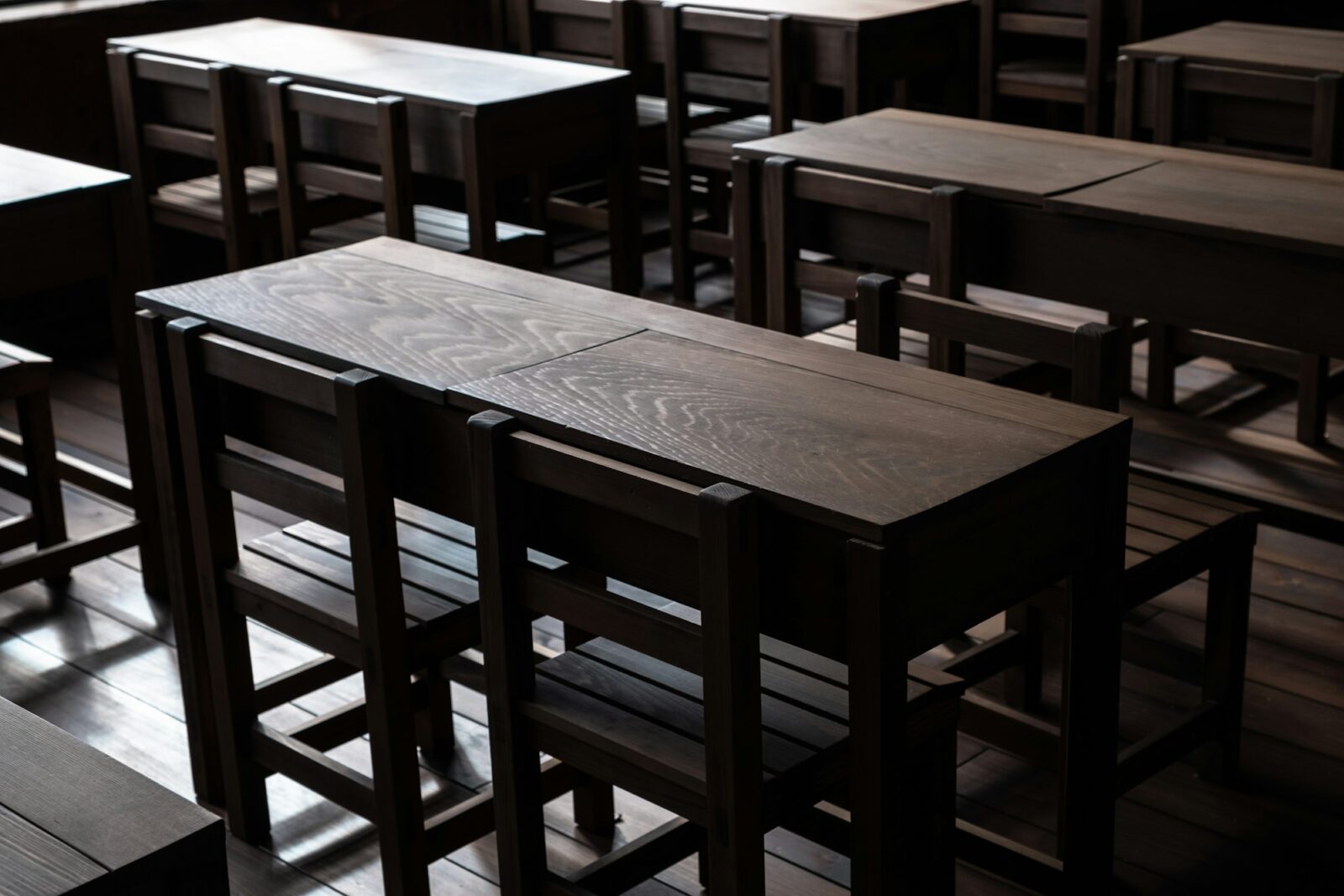 Brown wooden desks and chairs in an empty classroom