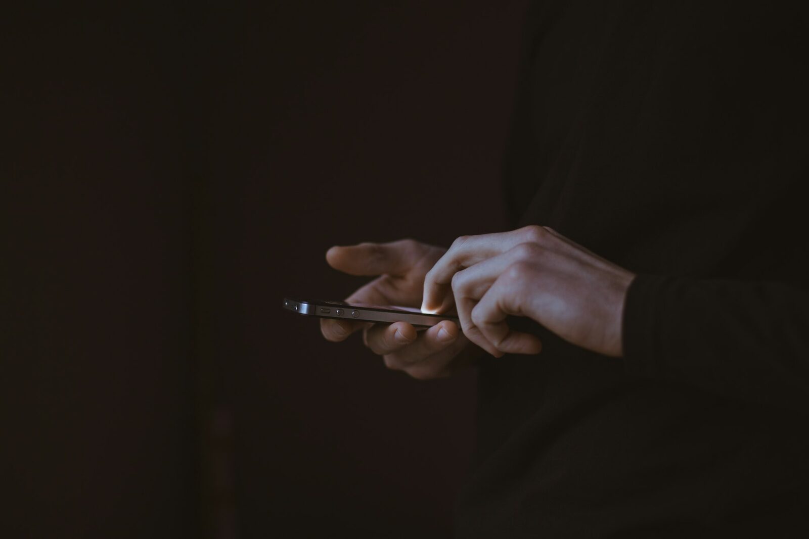 AAP Government introduces one-month session on ‘Responsible Use of Social Media’ Close view of a person holding a smartphone in both hands against a dark background
