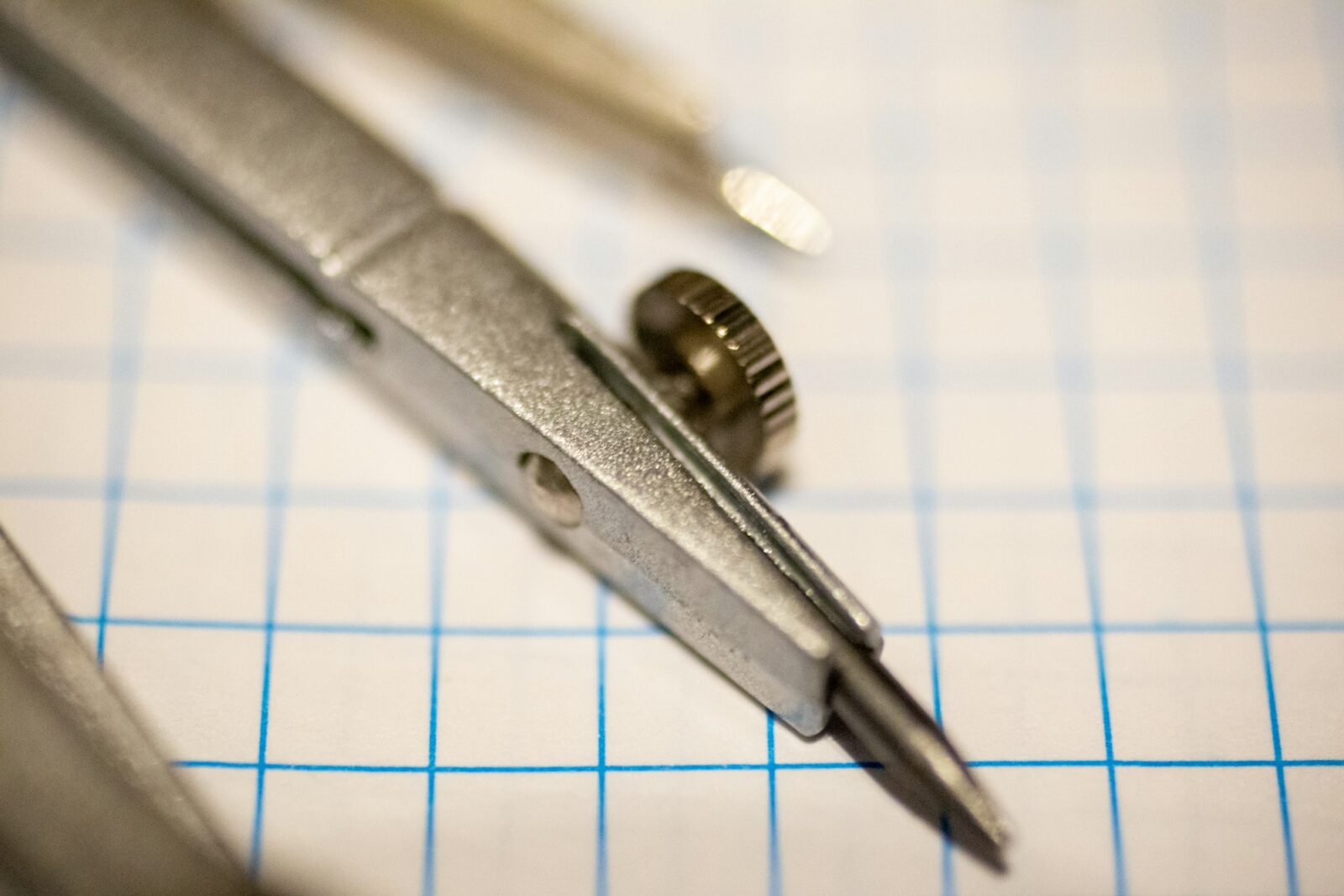 GB Pant Engineering College students call off protests Close view of a metal drawing compass resting on blue grid paper