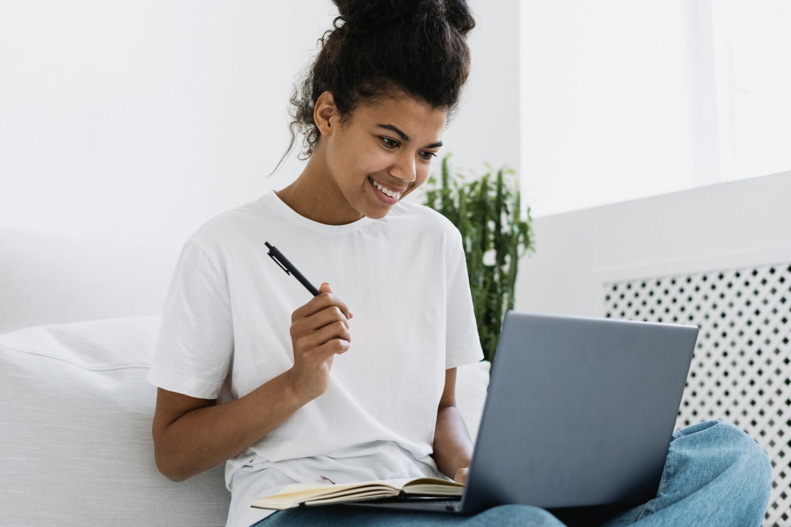 Union education minister lauds center’s decision to conduct online exams A woman in a white T-shirt holding a pen while working on a laptop