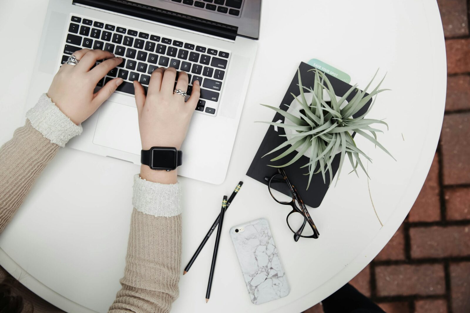 New government colleges can now get university affiliation by applying online in Uttar Pradesh Hands typing on a laptop on a white desk beside a potted aloe vera plant