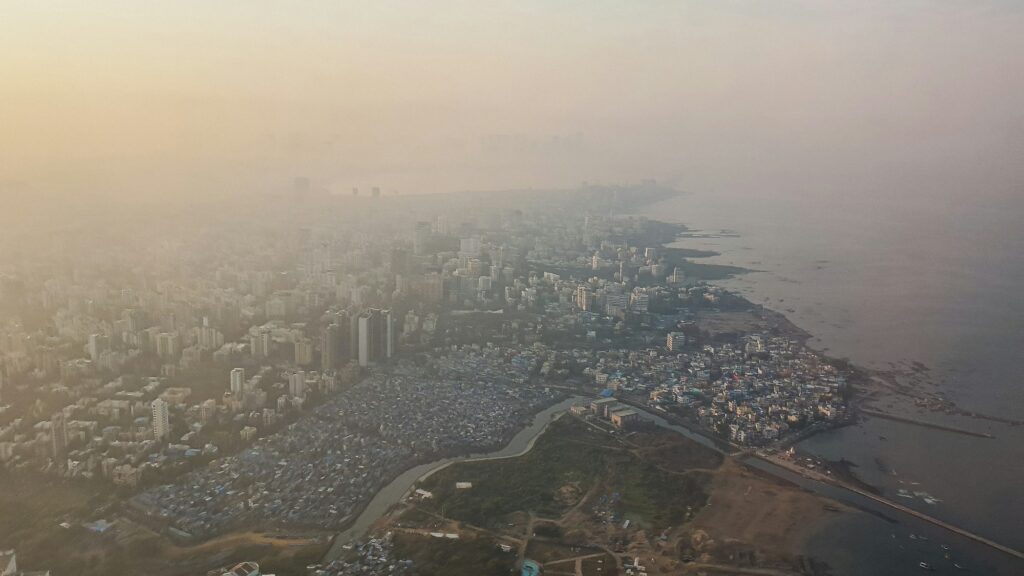 Aerial view of Mumbai and its coastline under a thick evening haze