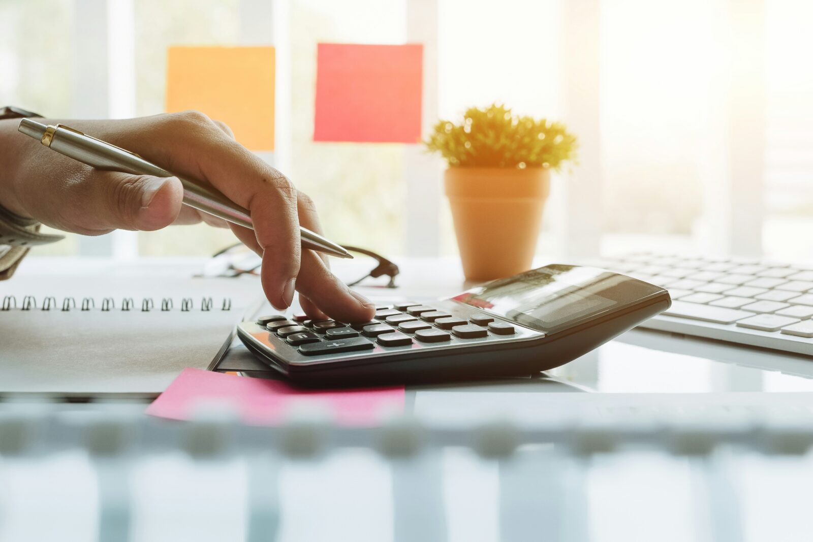 Failing to establish model schools, J&K govt to refund unutilized funds with accrued interest A person using a calculator on a desk beside a pen and a plant