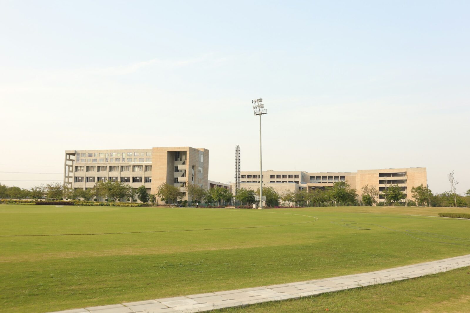 A grassy lawn with a college building in the background on a campus in Delhi