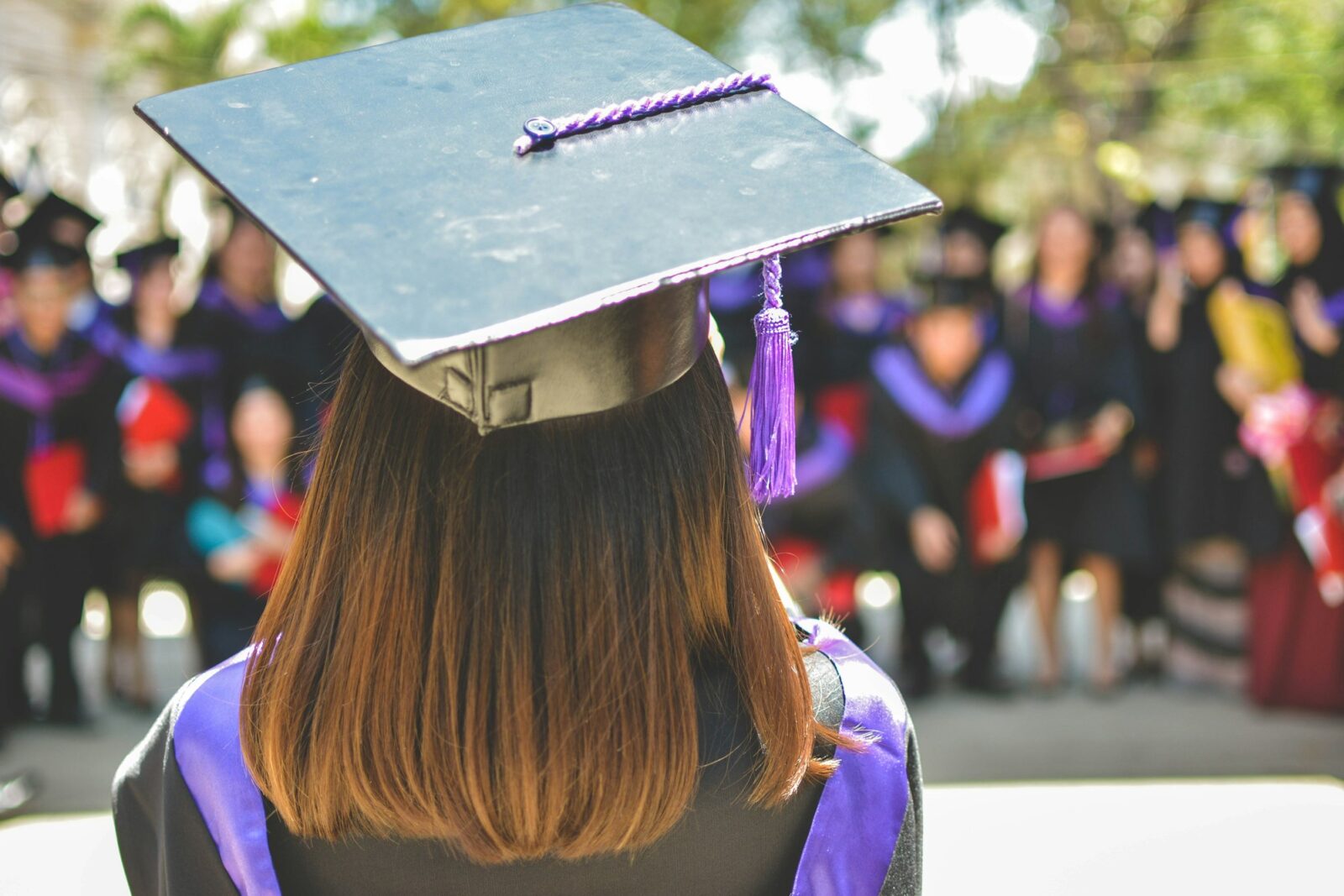 A graduate wearing an academic cap and gown, shot with a shallow depth of field