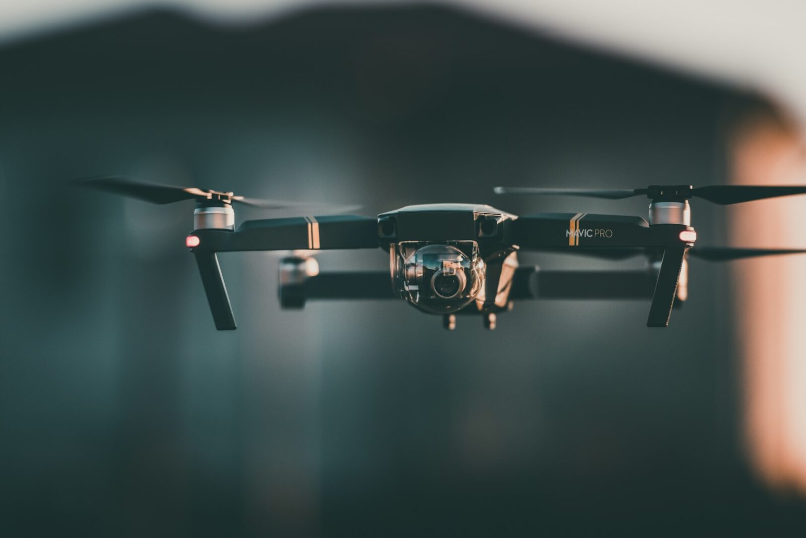 A small black drone flying in mid air
