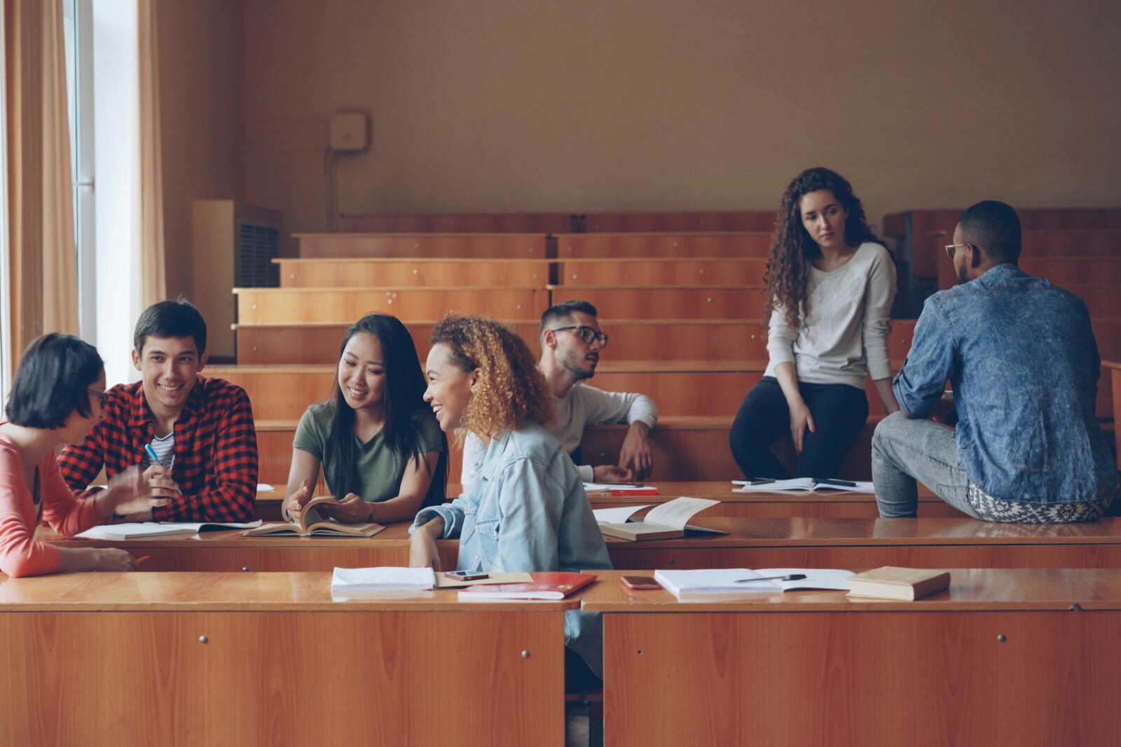 Top Colleges For B.com (Hons.) In Delhi University Students chatting in a lecture hall between classes