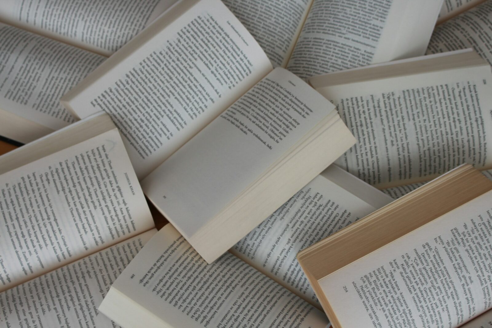 5 Iconic Books That You Can Finish Within A Day: A pile of open paperback books lying on top of one another
