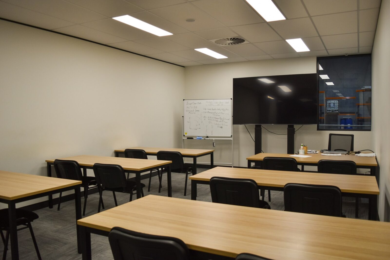 New learning methods and its impact in transformation of schools: A modern classroom with tables, chairs and a large screen at the front