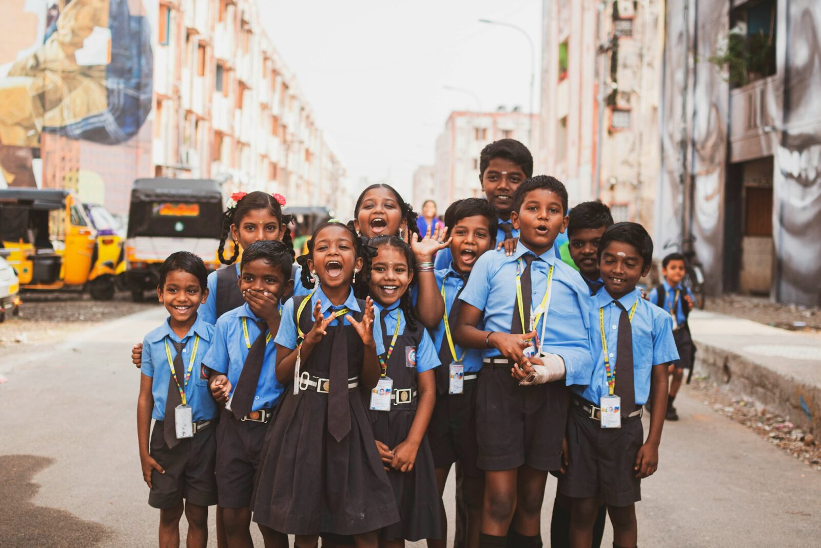 A group of schoolchildren standing together on a street in India on a sunny day