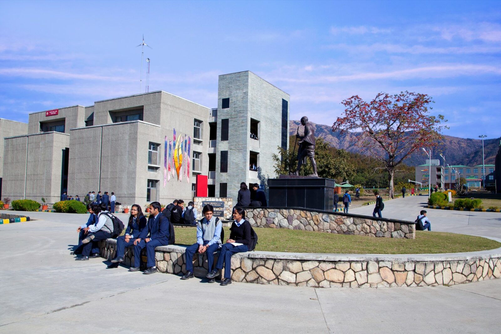 Students sitting together outside a building on a university campus in India