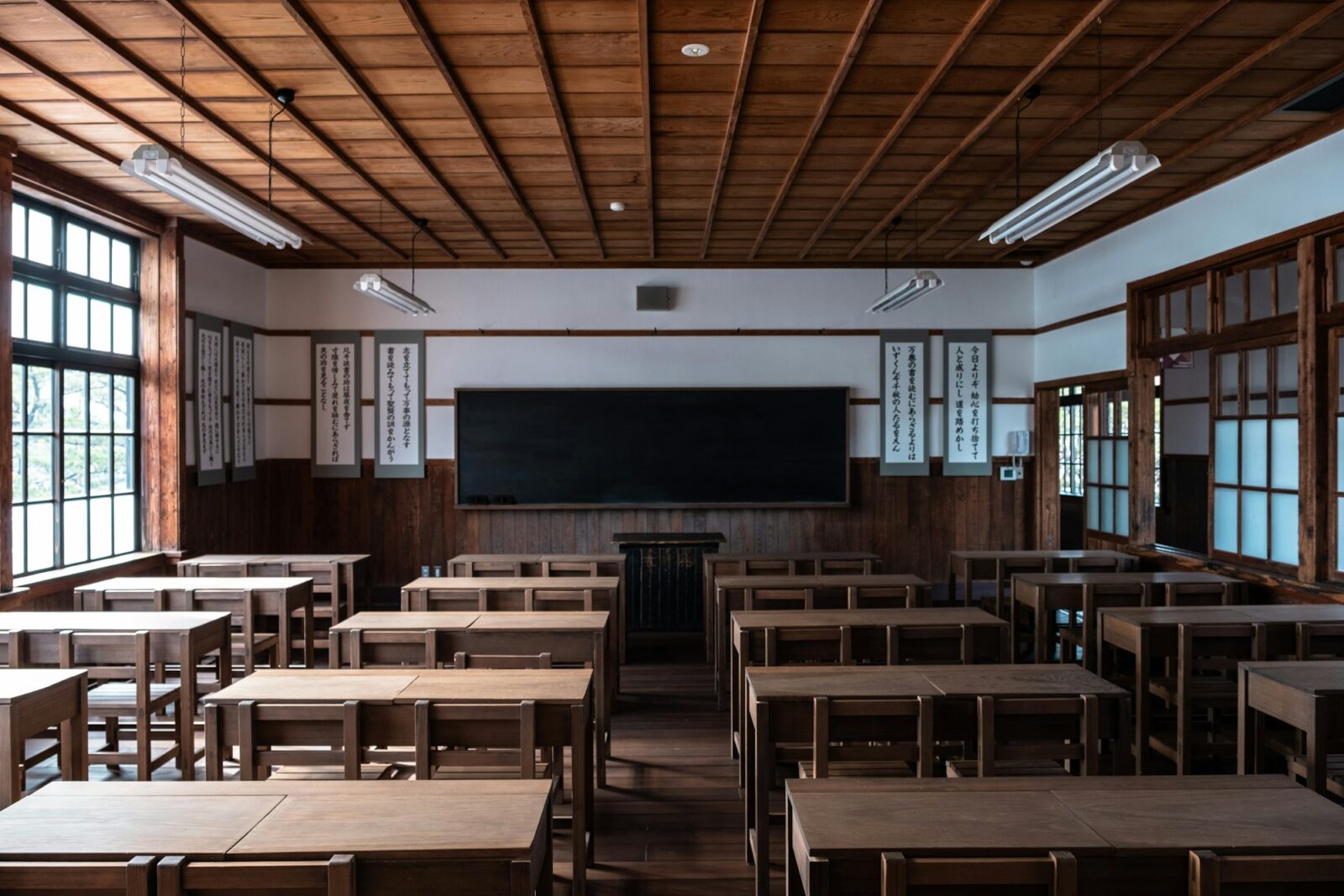 Pros and Cons of the educational system of Japan Rows of wooden desks and chairs facing a blackboard in a traditional Japanese classroom