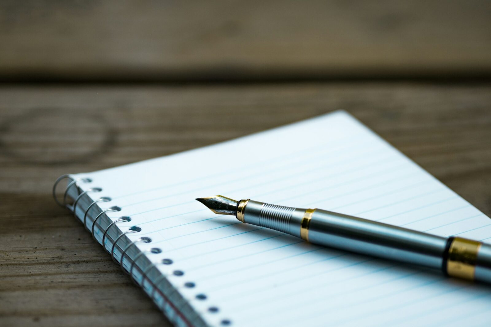 5 ways to improve your vocabulary fast Fountain pen resting on a spiral notebook