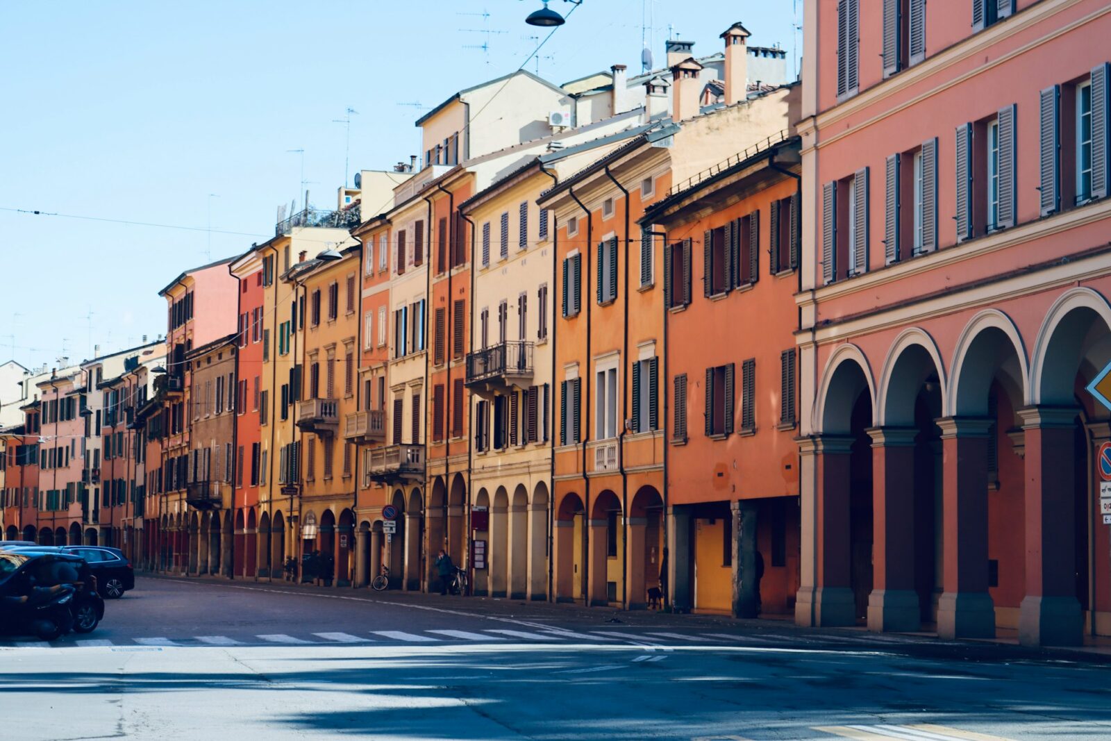 A quiet street lined with a row of old buildings in Bologna, Italy