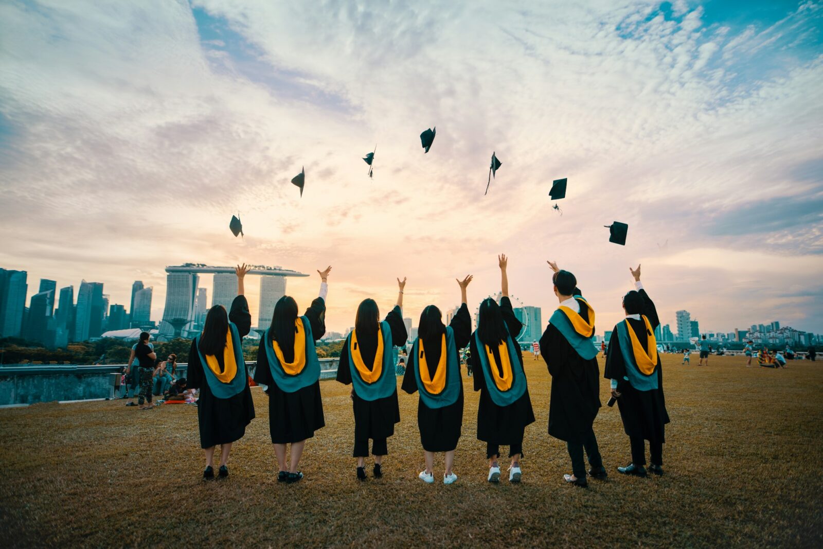 Graduates in gowns throwing their caps into the air at a graduation ceremony