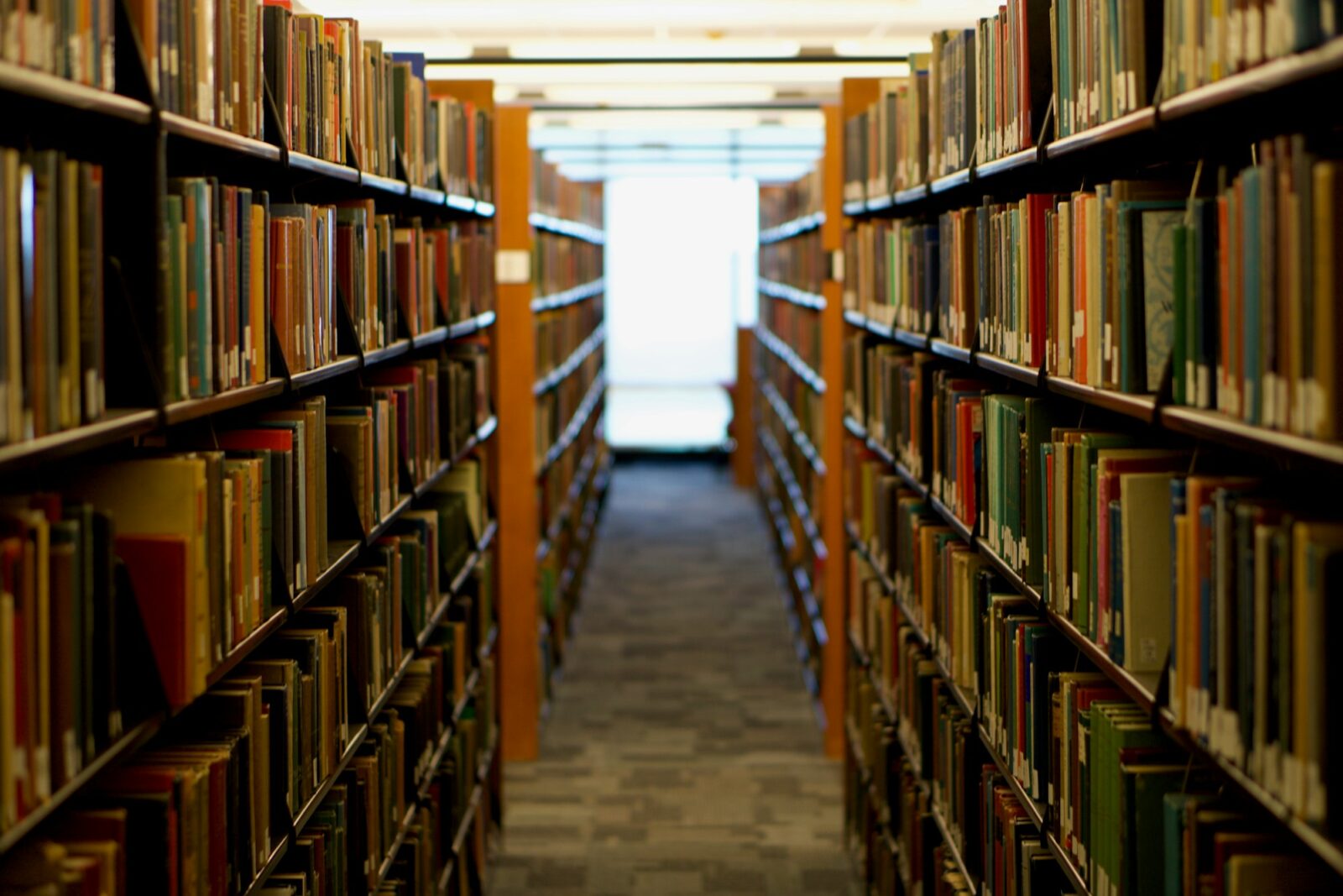 Library aisle with tall bookshelves filled with books