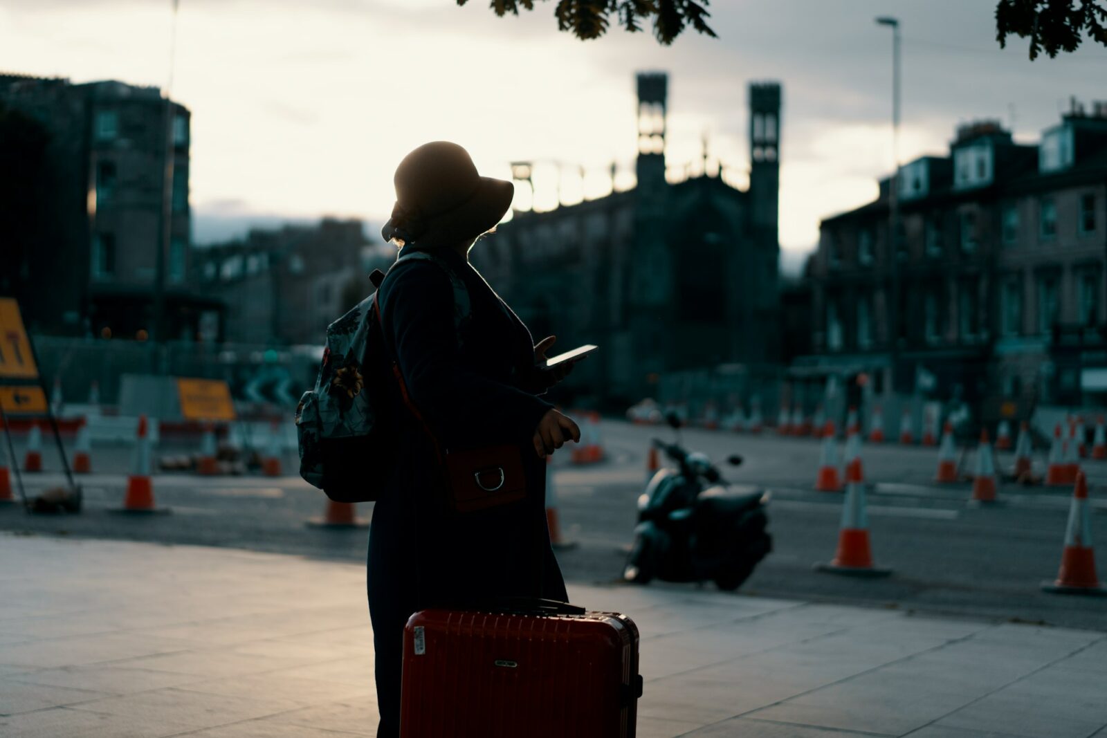 5 Hidden Benefits of Studying Abroad Traveller in a coat standing on a city street with luggage