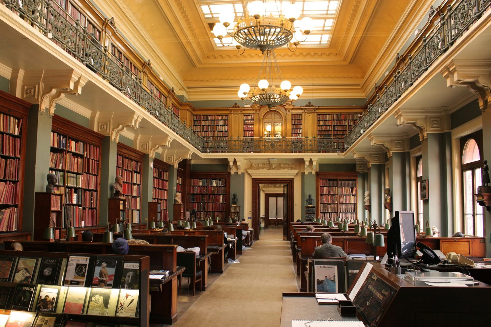 Best Courses in the UK (PG Courses in UK) Person studying at a desk inside a historic library in London