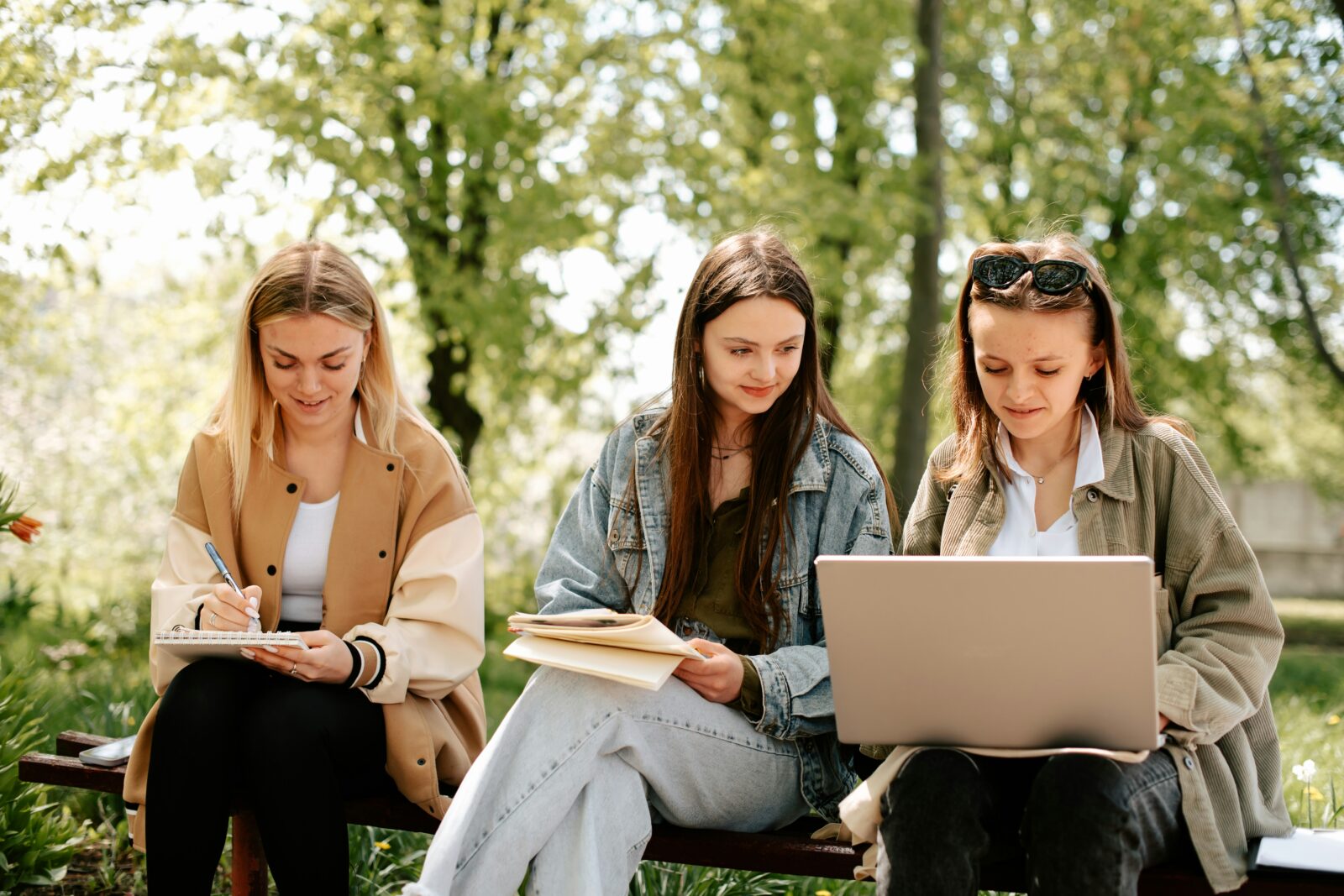 The Do's And Don'ts of Collaborative Learning Three young women studying together on a park bench with a laptop, notes and a book