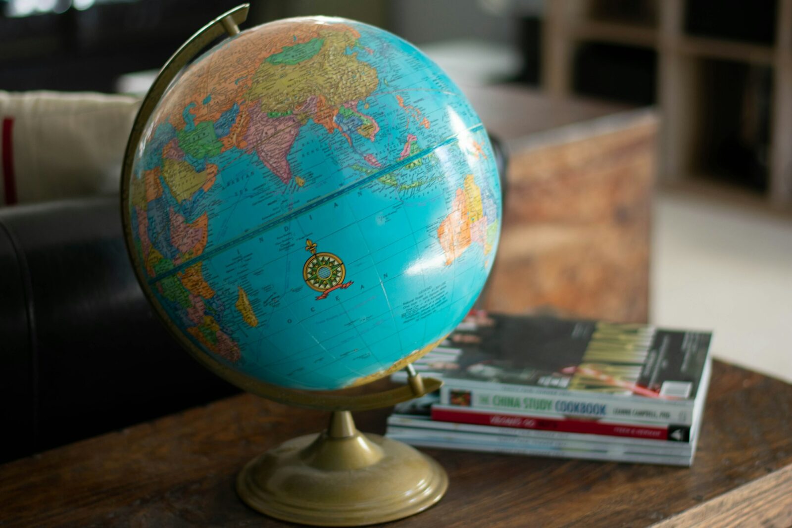 Blue and red desk globe beside a stack of books in a simple living room
