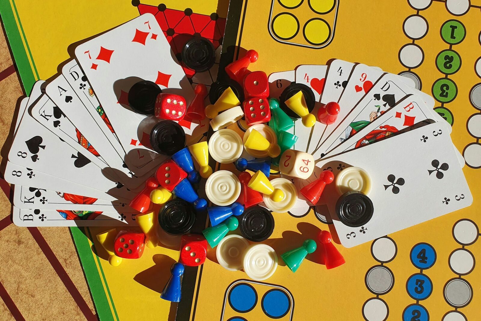The Benefits of Gamification in Education: Engaging Students through Play Assorted board game pieces, dice and playing cards spread across a table