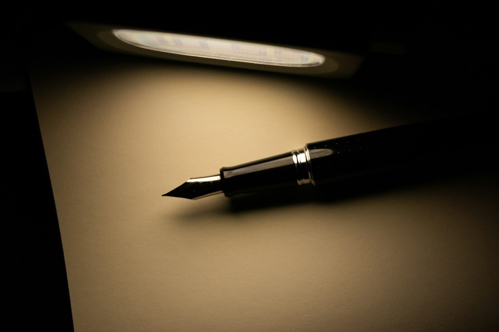 How To Write A Resume In 2023: Six Amazing tips! Fountain pen resting on a blank sheet of paper under a desk lamp