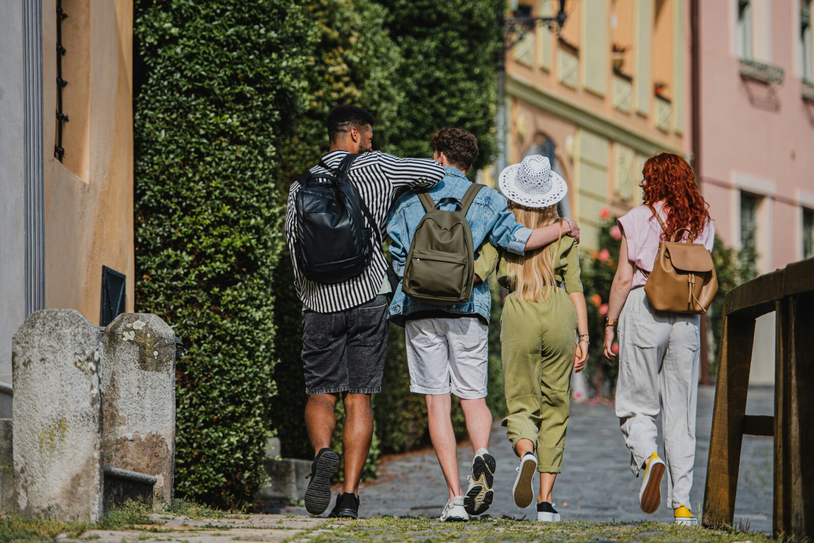 Rear view of a group of young people walking arm in arm through a town