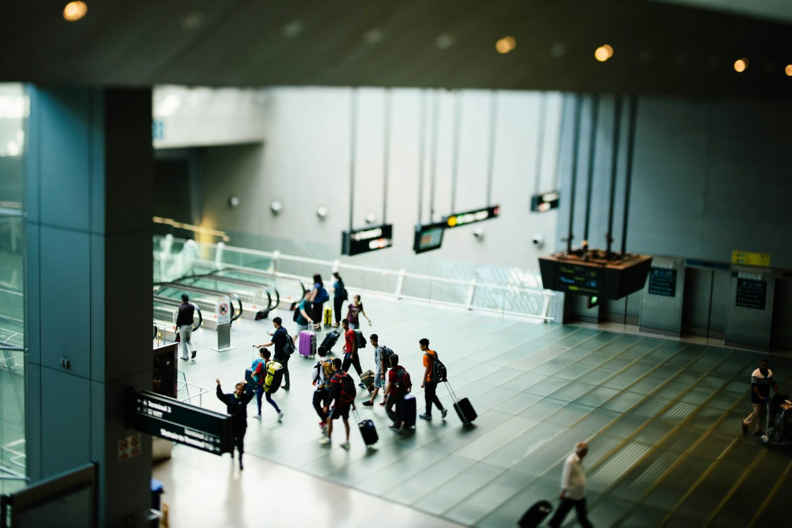 Travellers with luggage walking through a bright, modern airport terminal