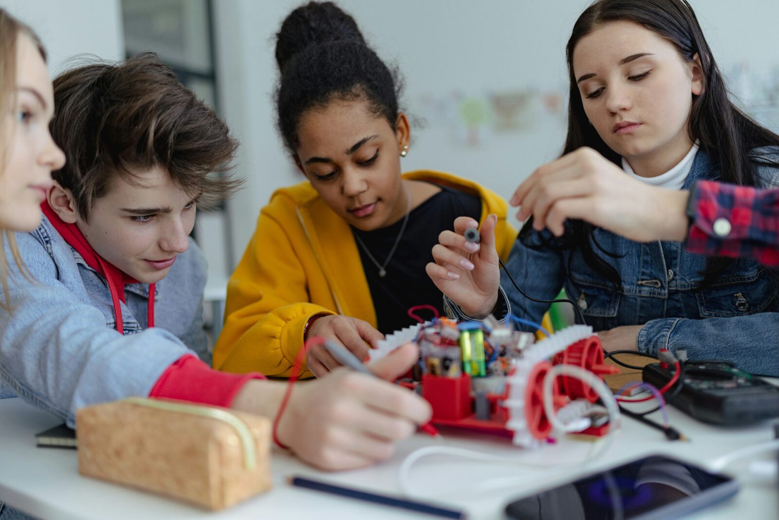 How AI in Education is Shaping School Education: A Look at the Benefits and Downsides Secondary school students building and programming small robots in a classroom