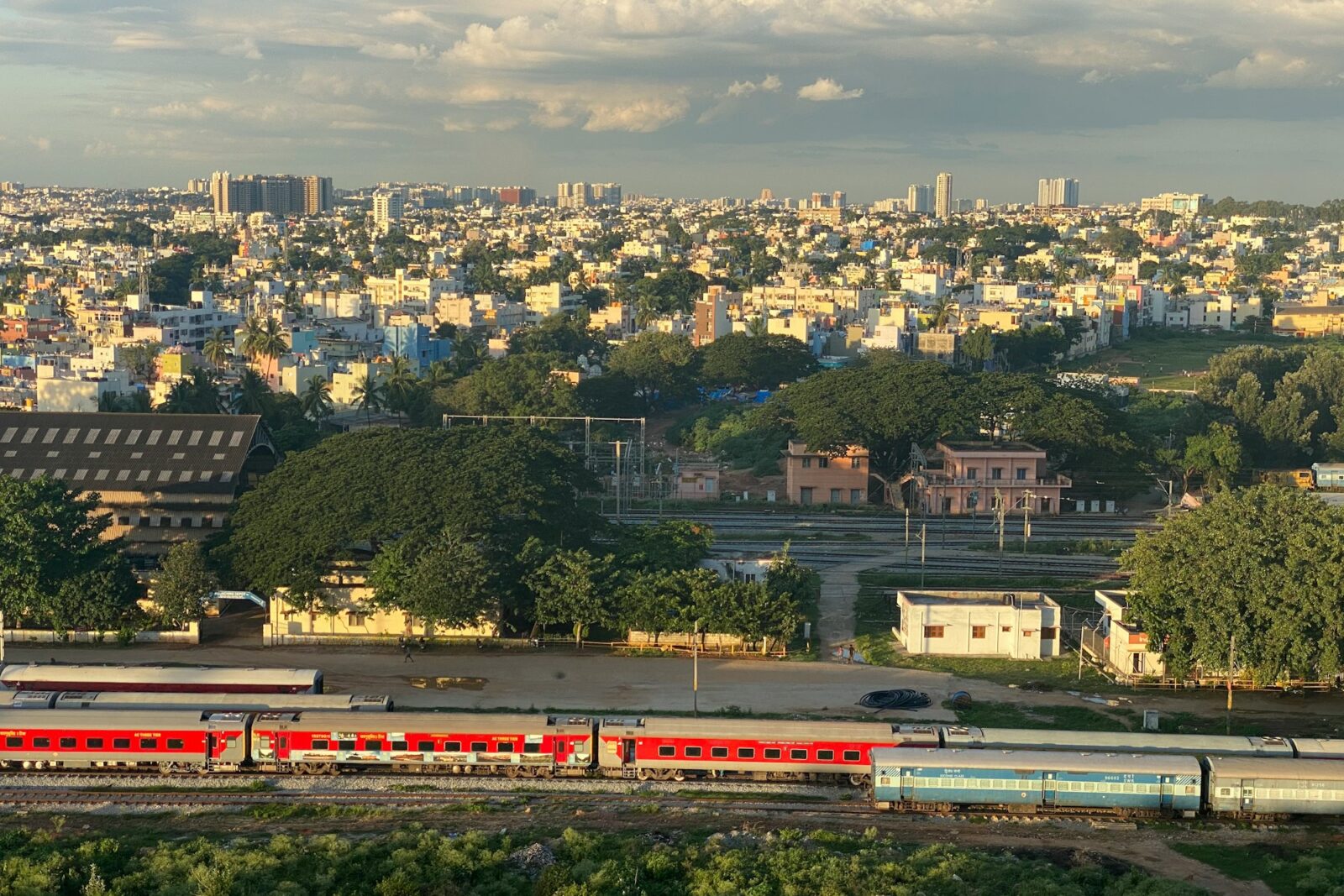 Top 5 EdTech Companies in India Wide view of an Indian city skyline with a red and white train in the foreground