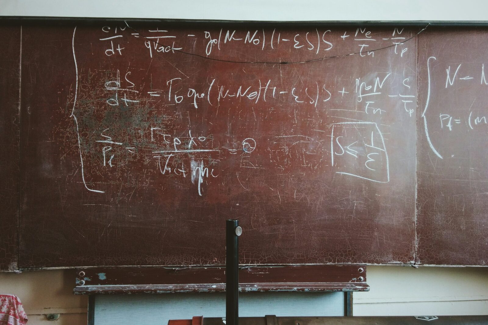 Mathematical formulas written in chalk on an old blackboard