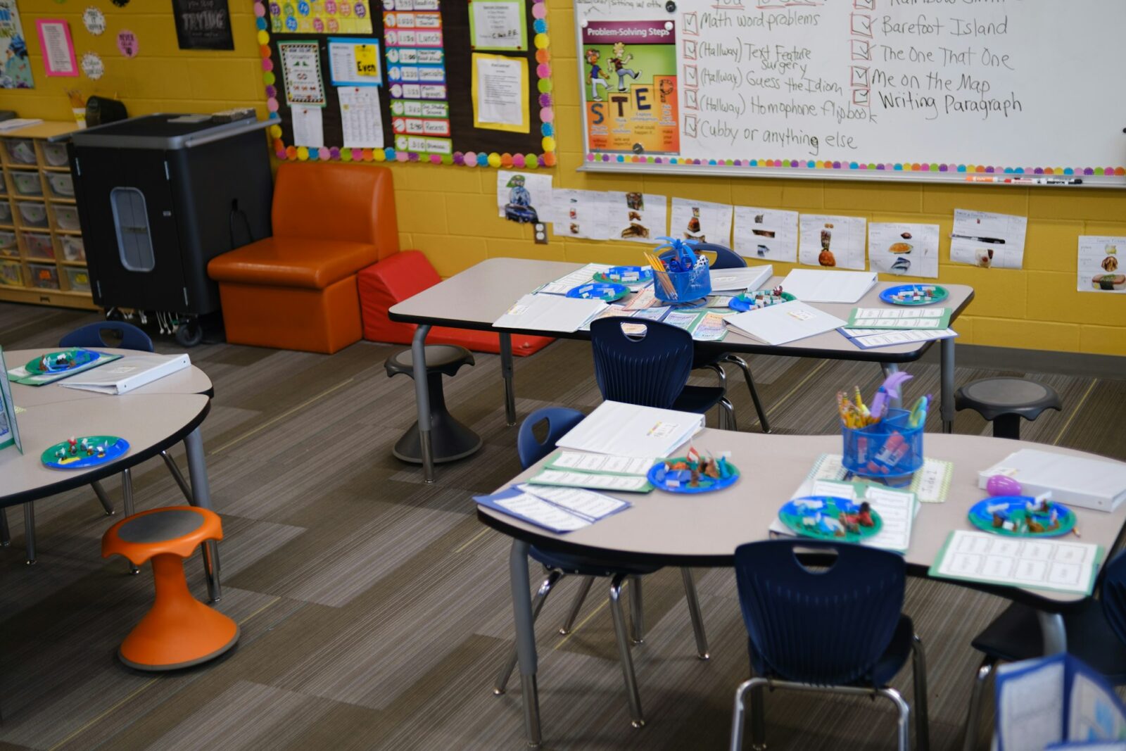 The Importance of Early Education: Building a Successful Future Tables with blue chairs and learning materials in a colourful primary school classroom