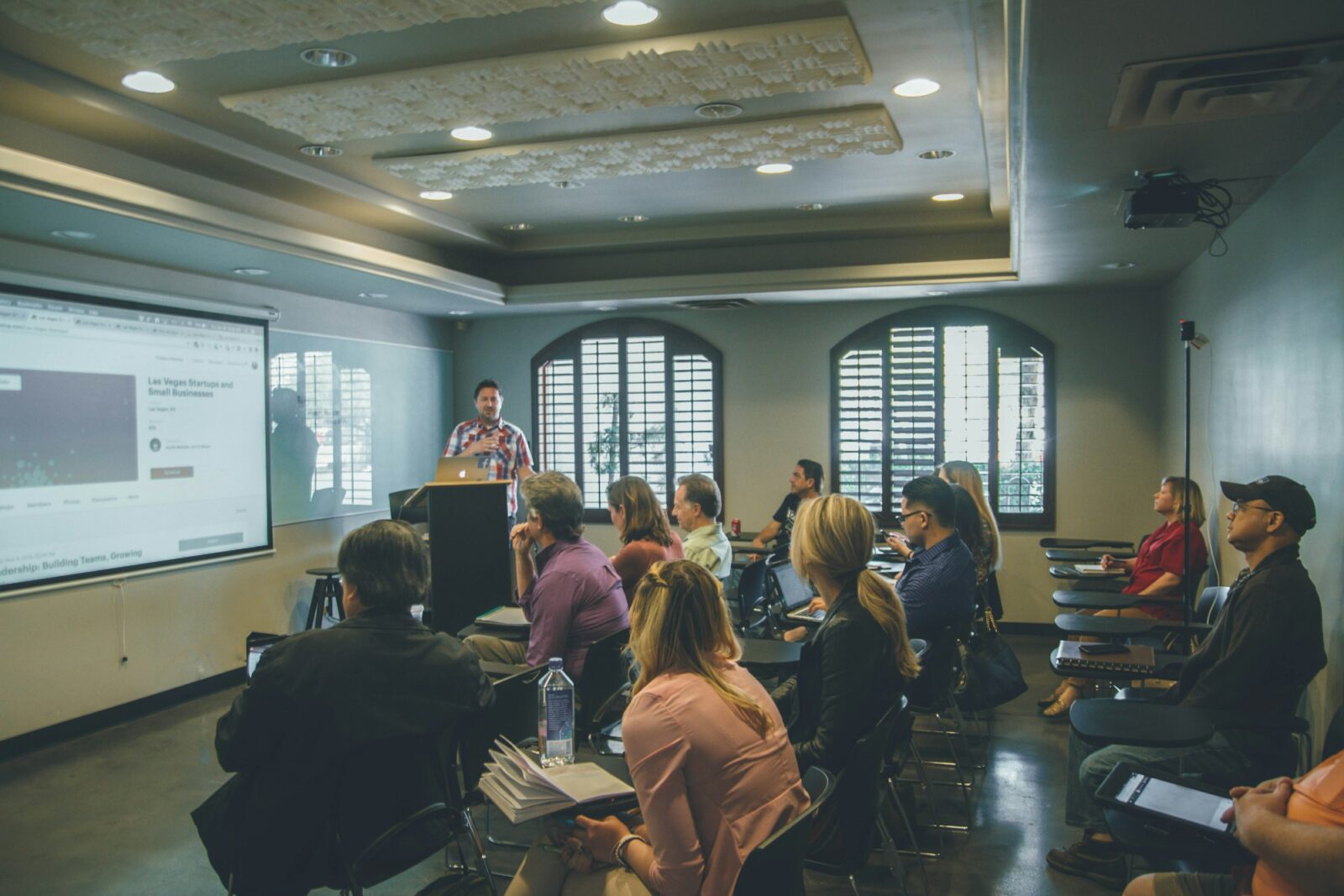 Students seated in a classroom facing a projector screen at the front of the room