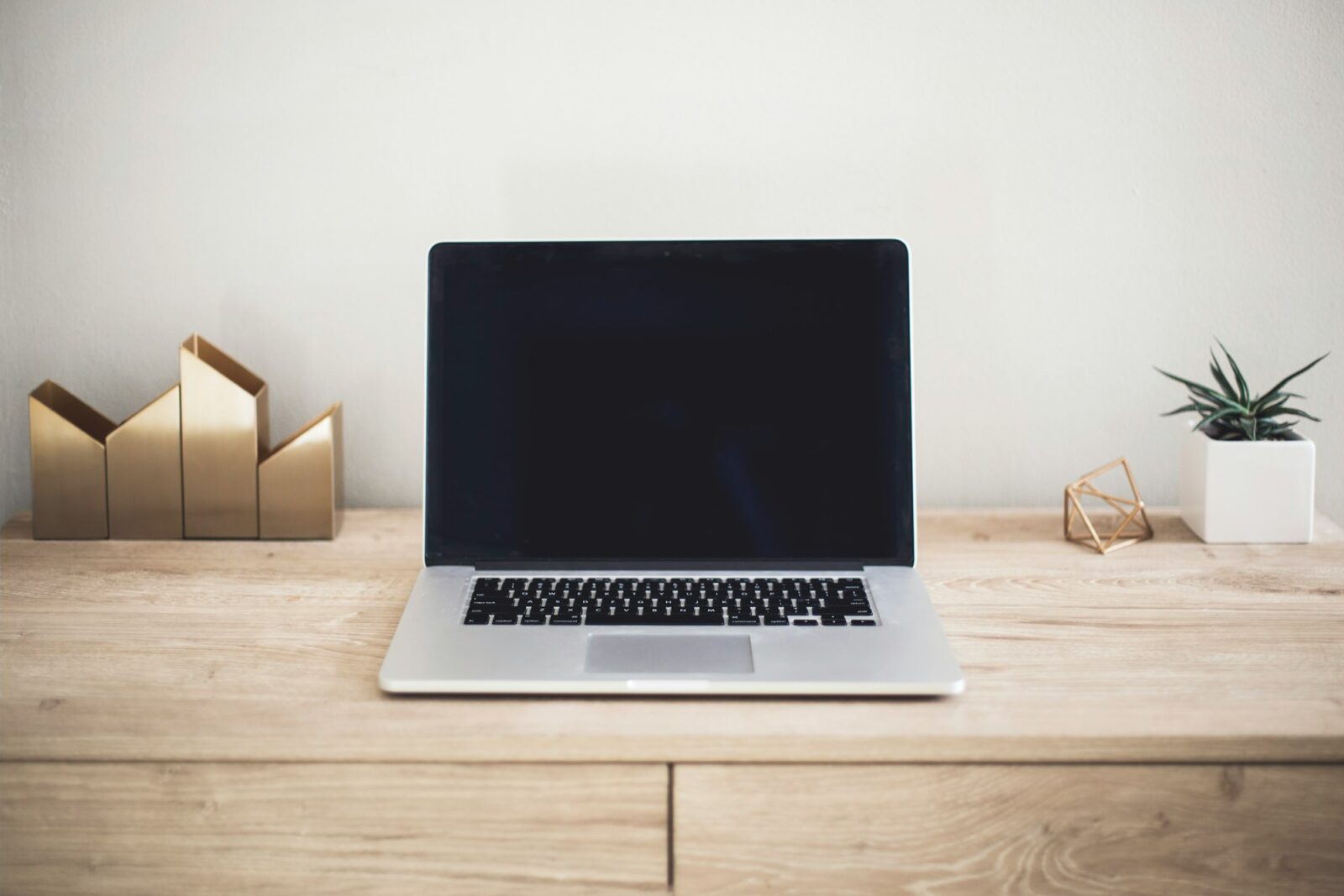 8 Online Courses Gaining Momentum in 2023 An open laptop on a wooden desk in a bright, minimal workspace