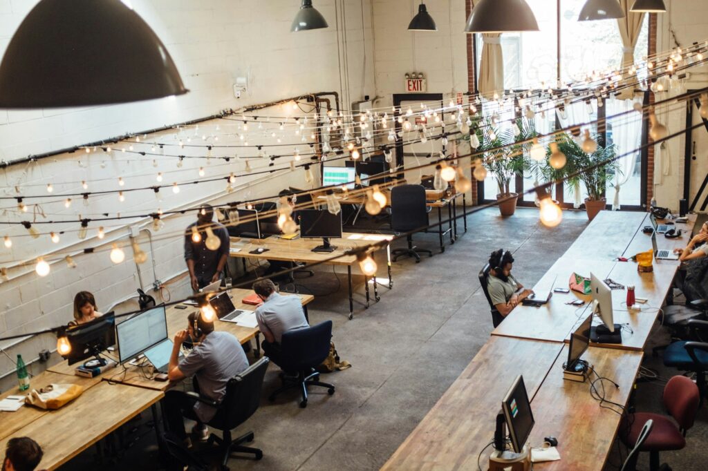 People working at long desks in a shared startup workspace