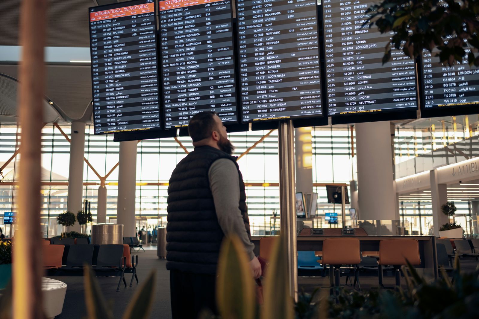 UK study visa applications fall 19% in year to September 2026 Departure boards in an airport terminal, with a traveller looking up at them